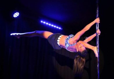 Candace Cane performs an overspilt on the pole