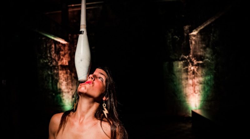 Dulce Duca a female juggler balances a juggling club on her face