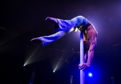 Dima Shine performs a deep back bend while hand balancing