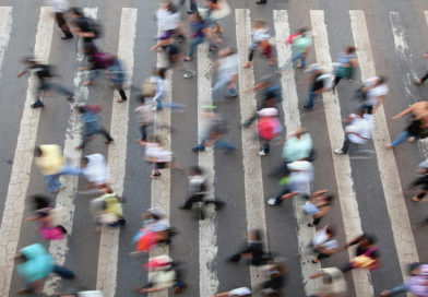 An aerial shot of a crowd of people walking through a street