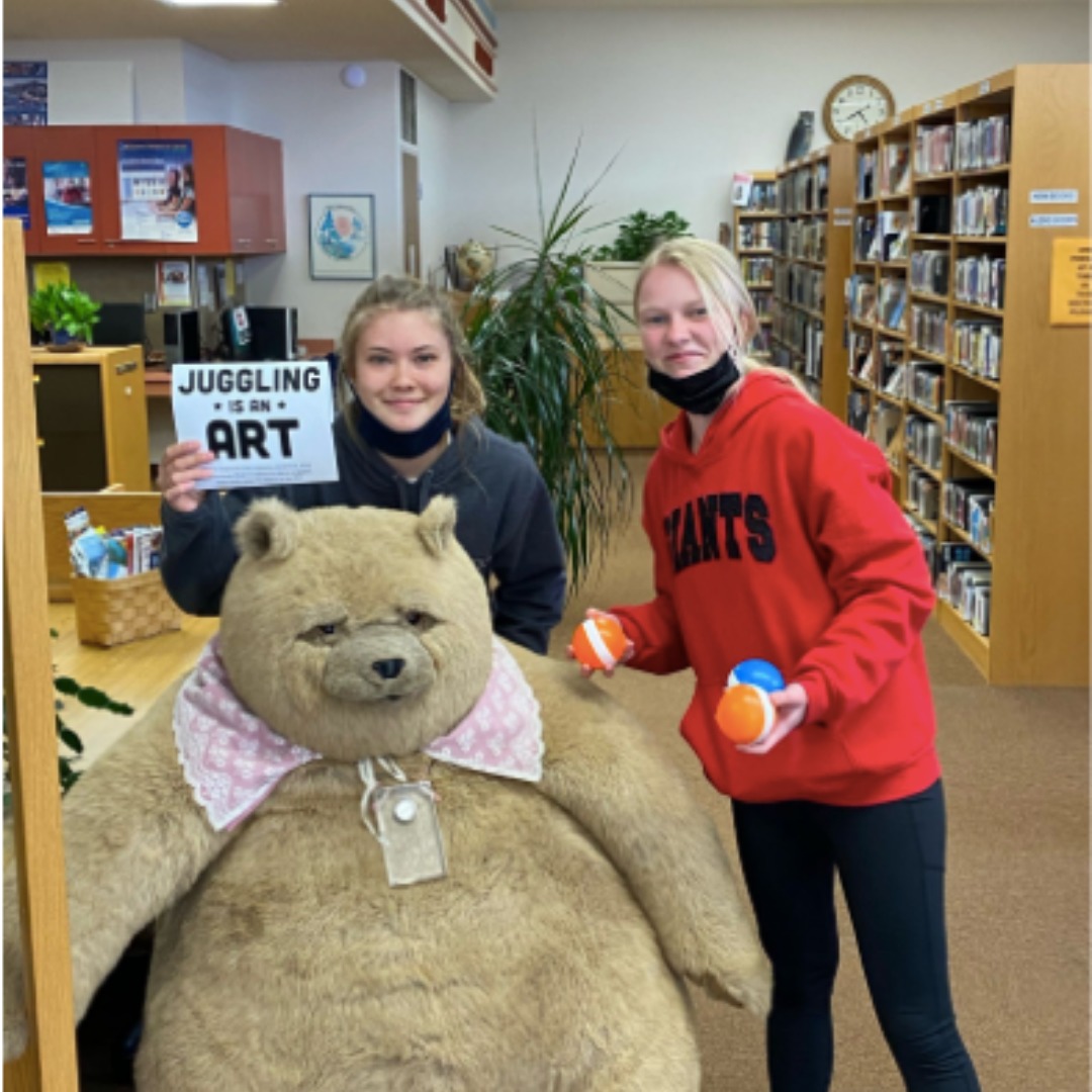 Two girls in an Arrowhead library hold up the balls and label of their juggling kits