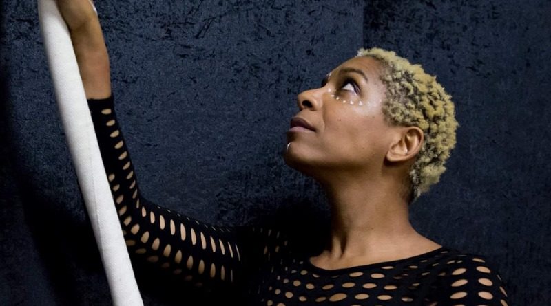 Kiebpoli Calnek, a Black transmasculine circus artist and director, holds their aerial pole