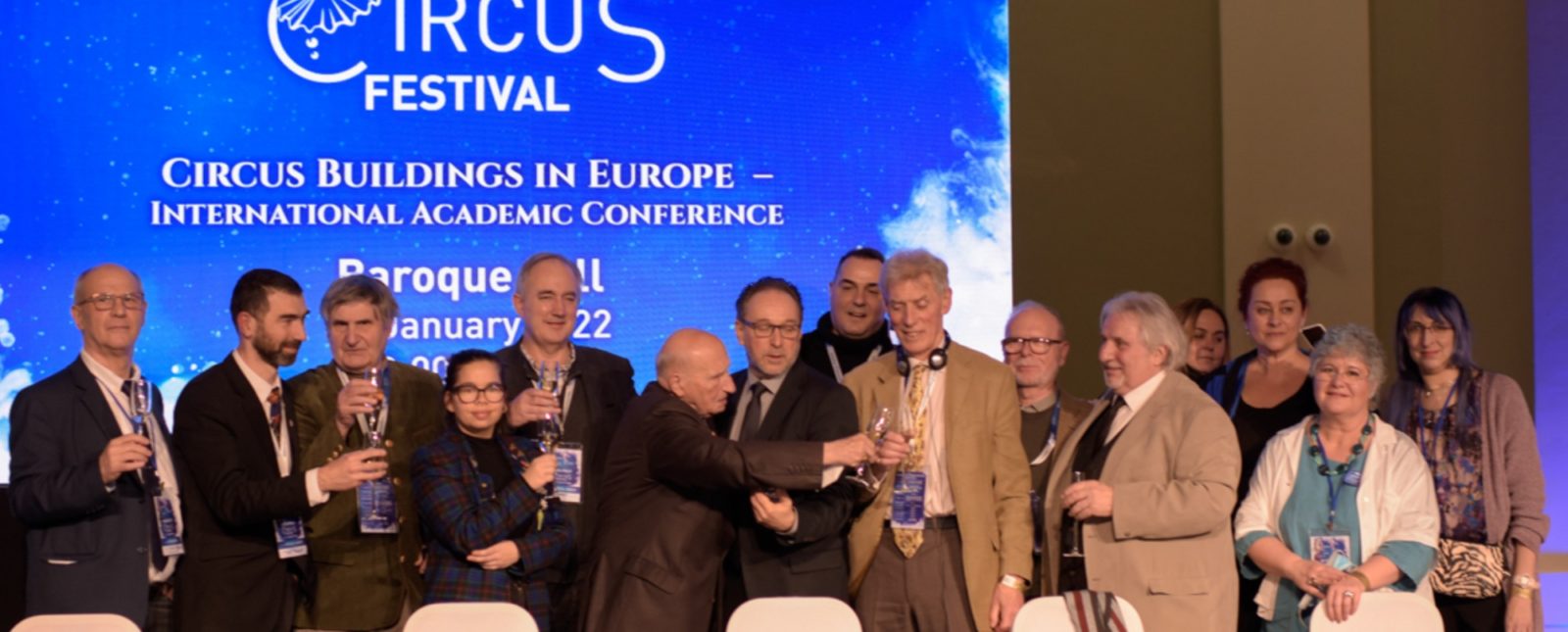 At the Circus Buildings in Europe Conference, a panel of circus history experts stands in front of a Budapest Circus Festival banner