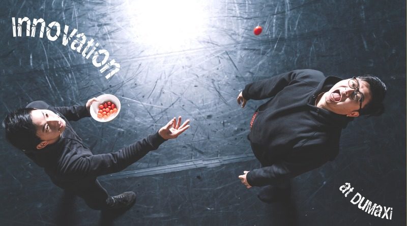 Male Taiwanese juggling duo does a trick where one throws cherry tomatoes into the other's mouth