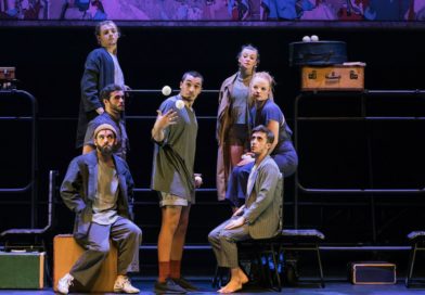 The 7 Fingers (Les 7 Doigts) show "Passagers." Onstage, six circus performers sit around a standing juggler