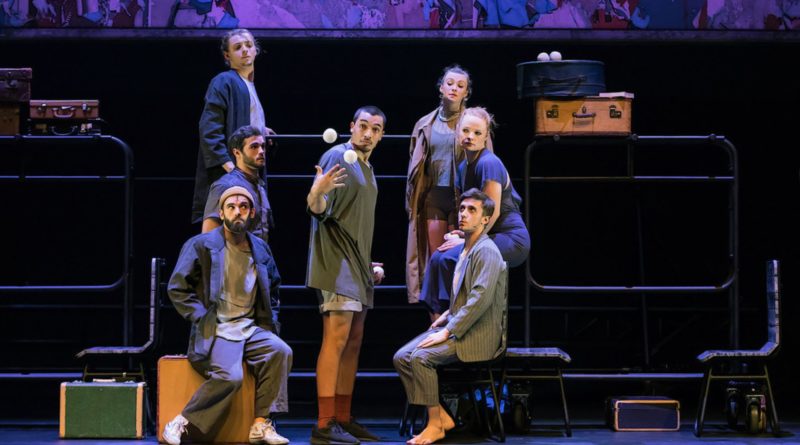 The 7 Fingers (Les 7 Doigts) show "Passagers." Onstage, six circus performers sit around a standing juggler