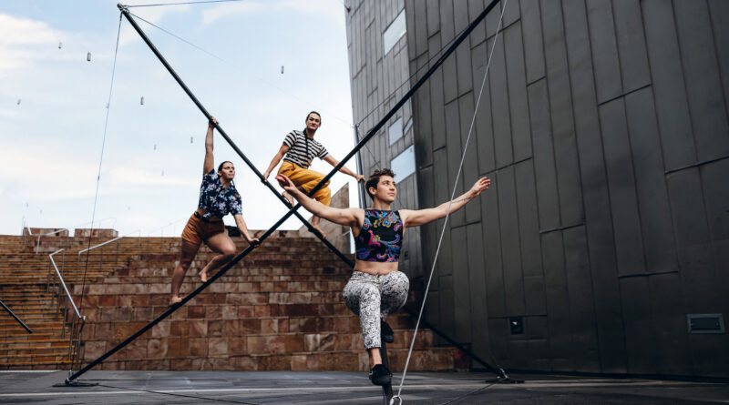 Three female acrobats climb a massive sculpture in One Fell Swoop Circus' "In Common"